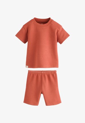 Cămașă cu mânecă scurtă, culoarea ruginii, și pantaloni scurți cu talie elastică asortați, dintr-un material moale cu textură de waffle, concepuți pentru copii.