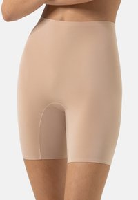 Shorts de shapewear beige en tissu lisse et extensible. Dotés d'une taille haute et d'une longueur mi-cuisse, ils offrent une apparence sans coutures.