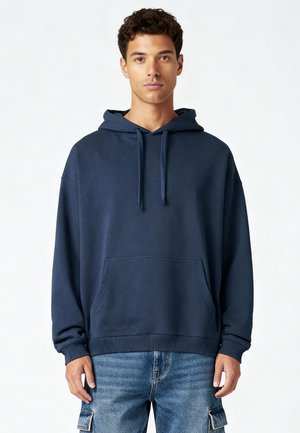 Marineblauwe hoodie gemaakt van een katoenmengsel, met een voorkauw, ribgebreide manchetten en een ontspannen pasvorm, gecombineerd met lichtblauwe cargobroeken.