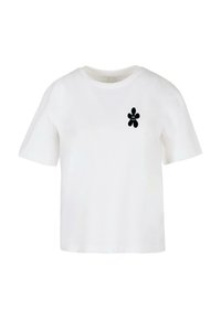 T-shirt blanc à manches courtes en coton, avec un design en forme de fleur noire sur la zone gauche de la poitrine. Col rond et coupe décontractée.