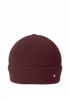 Dunkelbraune gestrickte Beanie-Mütze mit umgeschlagenem Bündchen und kleinem rundem Metalllogo am Bündchen vor weißem Hintergrund.