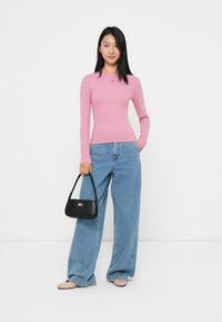 Pink long-sleeve top, light blue wide-leg jeans, black handbag with a logo, and light-colored flats. Simple and modern design.