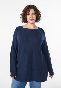 Maglione a maglia blu scuro con vestibilità ampia, scollatura larga e maniche lunghe. Presenta un motivo a trama e sottili spacchi laterali sull'orlo.