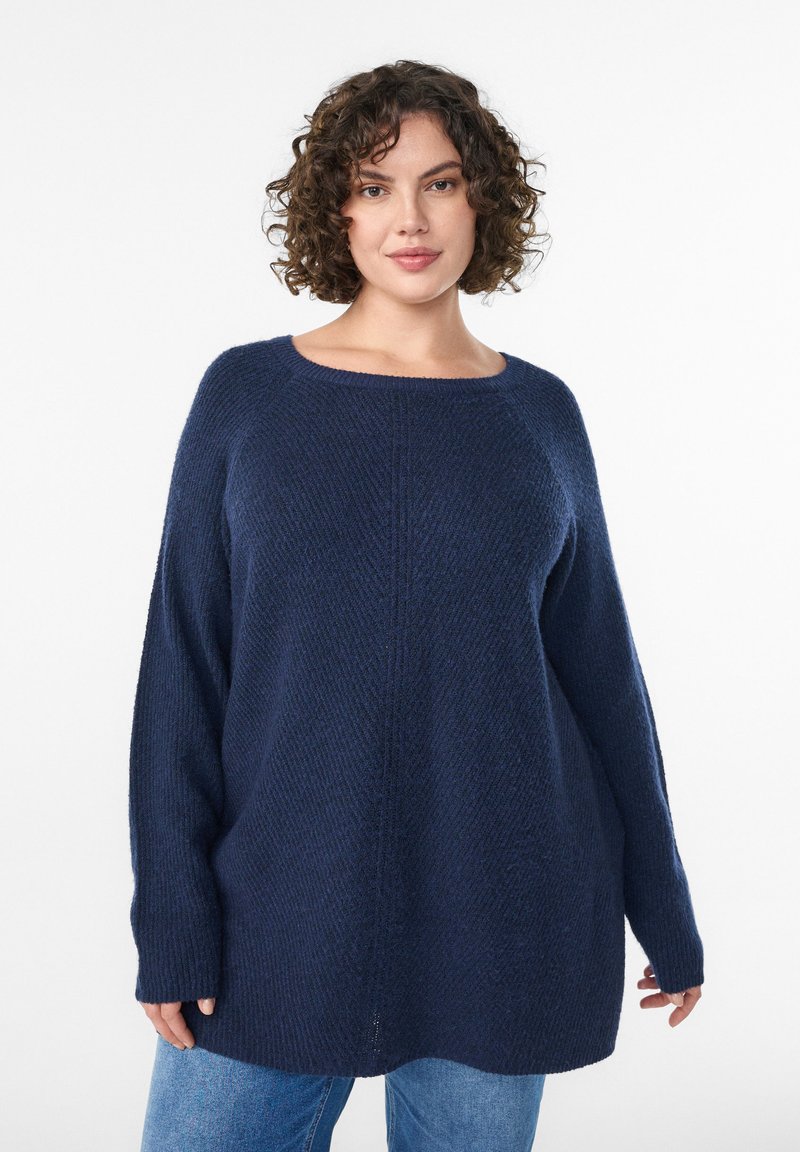 Maglione a maglia blu scuro con vestibilità ampia, scollatura larga e maniche lunghe. Presenta un motivo a trama e sottili spacchi laterali sull'orlo.