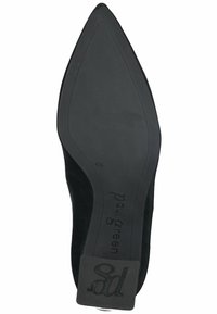 Zapato plano de ante negro con puntera puntiaguda y suela de goma texturizada. Presenta una marca en la plantilla y un acento de talón suave.