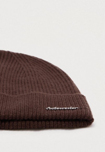 Brown knit beanie with a ribbed texture, featuring a folded cuff and white embroidered logo on the front.