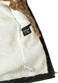 Schwarze Jacke mit offenem Reißverschluss, die das weiche weiße Fleecefutter mit braunem Kunstfellbesatz sowie das Navahoo-Label innen zeigt.
