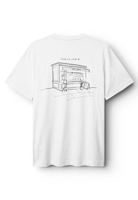 Valkoinen puuvillainen T-paita, jossa on minimalistinen musta viivapiirros kioskista ja yläpuolella teksti "DANISH DENIM". Lyhyet hihat, pyöreä kaulus.