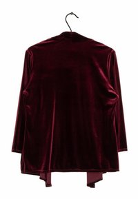Cardigan in velluto borgogna con maniche lunghe, texture liscia, design a frontale aperto e dettagli di orlo asimmetrico. Appeso a un gancio nero.