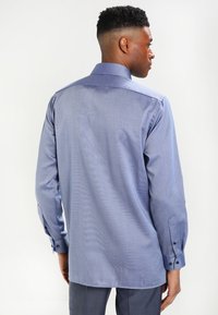 Light blue long-sleeve shirt with a subtle texture, slim-fit design, and buttoned cuffs. Features a straight hem and a classic collar.