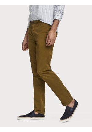Hnědé bavlněné chino kalhoty se slim fit střihem, s bočními kapsami a hladkou Texturou. Spárovány s námořnickými slip-on botami s tkaným vzorem.