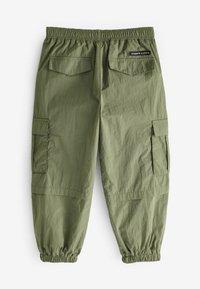 Pantaloni cargo verde oliva con vita elastica, orli affusolati, multiple tasche e un tessuto testurizzato che mostra una leggera lucentezza.