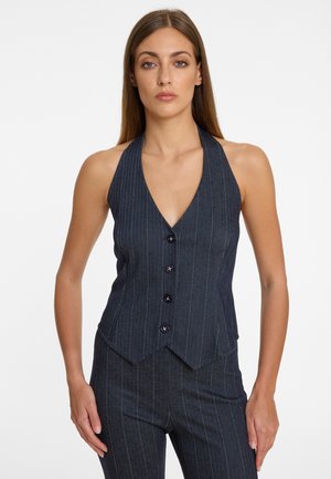 Gilet halter neck en denim foncé avec des rayures verticales, décolleté en V et fermeture à cinq boutons à l'avant. Coupe ajustée avec un ourlet pointu.