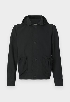 Giacca corta nera realizzata in tessuto leggero, con chiusura frontale a bottoni, due tasche con coulisse e cappuccio.