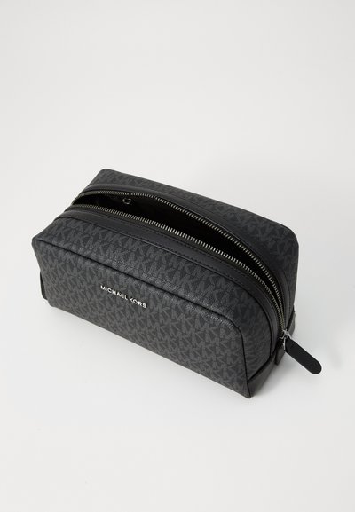 Trousse cosmétique noire avec motif monogramme Michael Kors, texture lisse, double zip, forme rectangulaire et design épuré.