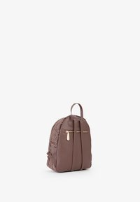 Zaino in pelle marrone con design floreale in rilievo, dettagli con zip dorate e due maniglie. Forma compatta con spallacci regolabili.