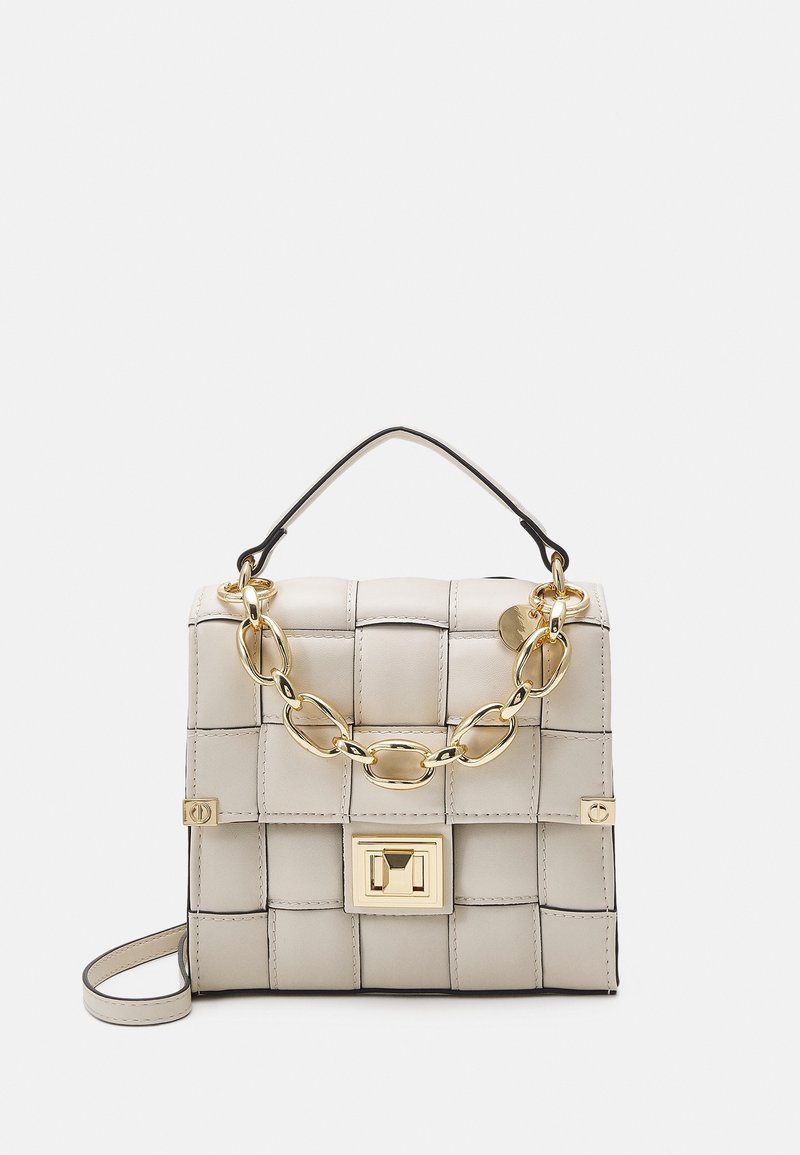 Beige leather handbag with a woven design, gold chain accent, and a flap closure featuring a rectangular clasp. Includes a black handle.