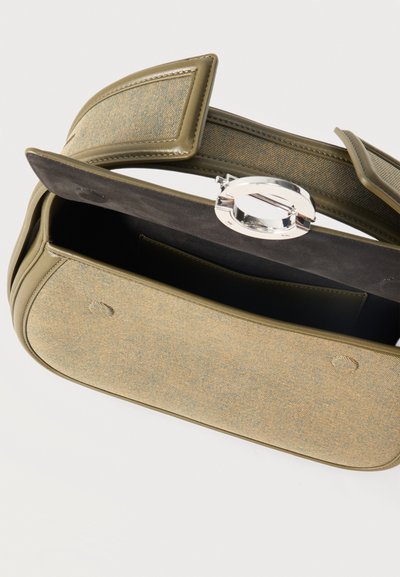 Sac d’épaule rectangulaire en tissu vert olive avec garniture en cuir, sangle large et fermoir circulaire argenté, montré ouvert révélant l’intérieur noir.