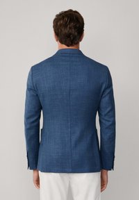 Pánský blazer z tmavě modré látky s texturovaným povrchem. Obsahuje jeden rozventilovaný zadní díl, klopové límce a manžety na knoflíky. Přiléhavý střih.