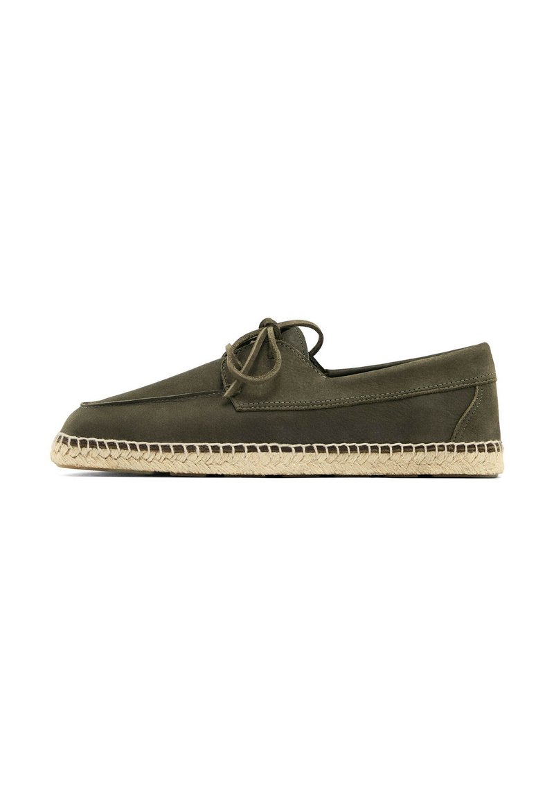 Grønne ruskind slip-on sko med spids tå, udstyret med en vævet jutesål og matchende snørebånd. Enkel design med side-syningsdetaljer.