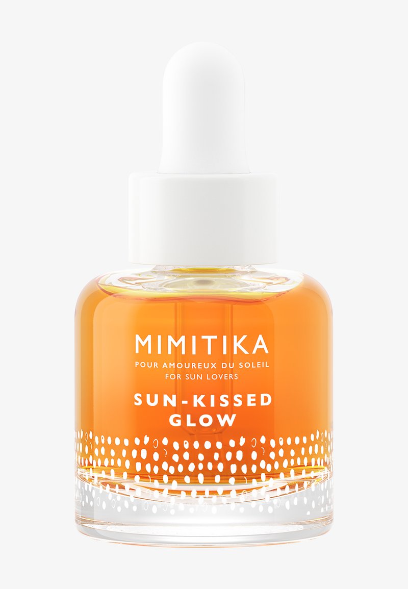 Flacone contagocce in vetro trasparente con liquido arancione etichettato Mimitika Sun-Kissed Glow per gli amanti del sole, tappo bianco e design a pois vicino alla base.
