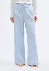 Φαρδιά παντελόνια σε ανοιχτό γαλάζιο χρώμα με ελαστική μέση και κορδόνι. Κατασκευασμένα από λείο ύφασμα, με άνετη εφαρμογή και απλό σχέδιο.
