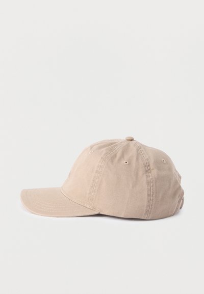 Μπεζ βαμβακερό καπέλο του μπέιζμπολ με κυρτή γείσο και οπές αερισμού, εμφανιζόμενο από το πλάι σε λευκό φόντο.