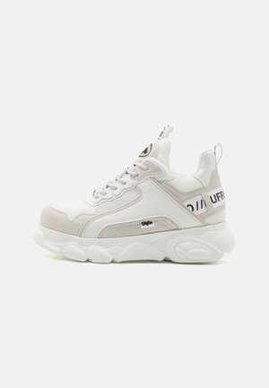 Biele a svetlo béžové tenisky s hornou časťou z materiálu s mriežkovaním a syntetickej kože, hrubou gumovou podrážkou a kontrastným čiernym logom po boku.