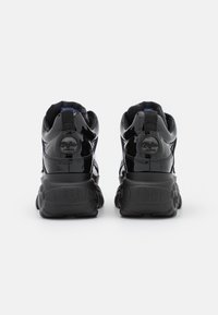 Sorte patentlæder sneakers med højt design, struktureret sål og en blå accent indvendigt. Har logo på hælen.