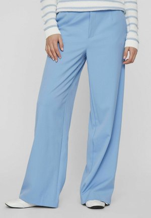 Pantaloni ampi blu chiaro realizzati in tessuto morbido, con una parte anteriore plissettata, tasche laterali e una texture liscia.