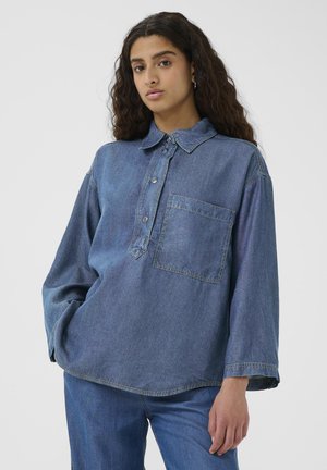 Denimshirt met een kraag met knopen, een voorzak en brede mouwen. Medium blauwe kleur, licht vervaagde textuur en een casual pasvorm.