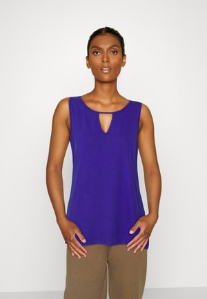 Top roxo sem mangas com um detalhe em forma de buraco na gola, feito de um tecido suave. O design apresenta um corte relaxado e uma bainha arredondada.