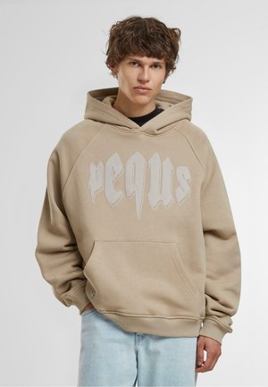 Beige kapucnis felső kenguru zsebbel, a frontján feltűnő fehér grafikai szöveggel, puha anyagból készült, laza szabású, bordázott mandzsettákkal.