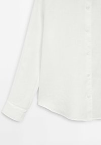 Witte linnen blouse met lange mouwen, een knoopsluiting aan de voorkant en een licht gebogen zoomlijn. Gladde textuur met minimale details.