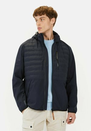 Navy zip-up jacket with a quilted upper section, adjustable hood, and side pockets; features a smooth texture and lightweight material.