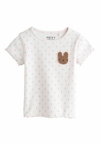 White cotton t-shirt with short sleeves, featuring pink polka dots and a brown bunny patch on the chest. Scalloped edges.