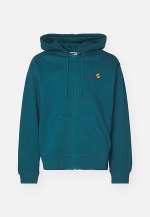 Zila kapucīna džemperis ar rāvējslēdzēja aizdari, priekšā kabatu, regulējamu kapuci ar auklu un izšūtu logotipu uz krūtīm. Mīksts kokvilnas maisījuma audums.