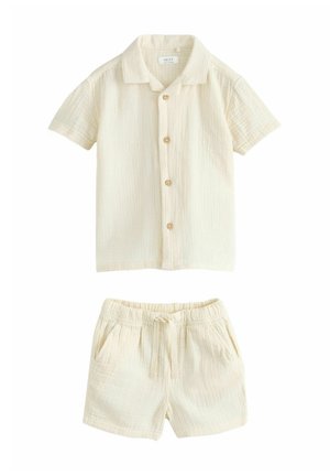 Cream-colored short-sleeve button-up shirt with matching elastic waist drawstring shorts, both made of lightweight textured fabric.