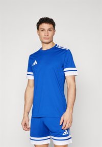 Blue athletic jersey and shorts with white trim. Features Adidas logo and three stripes on shoulders and shorts. Smooth fabric, modern fit.