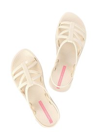 Sandali in gomma bianchi con una soletta testurizzata, caratterizzati da più cinturini sottili e dettagli del logo rosa sulla soletta.