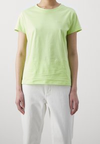 Jasnozielony bawełniany t-shirt z okrągłym dekoltem i krótkimi rękawami. Zawiera subtelne logo "BOSS" na klatce piersiowej, w zestawieniu z białymi spodniami.
