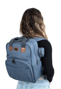 Blå tygryggsäck med bruna läderdetaljer, flera dragkedjefack, vadderade remmar och ett handtag på toppen; kompakt och strukturerad design.