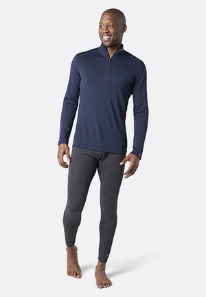 Marineblå langærmet zip-up top og tætsiddende grå leggings. Begge lavet af blødt, strækbart stof. Ingen mønstre; glat overflade og atletisk design.