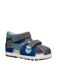 Blue and gray children’s sandal with two adjustable Velcro straps and a closed reinforced toe on a white sole.
