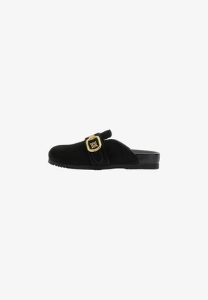 Mule in camoscio nero senza lacci con fibbia decorativa dorata e suola piatta, progettato per un uso casual.