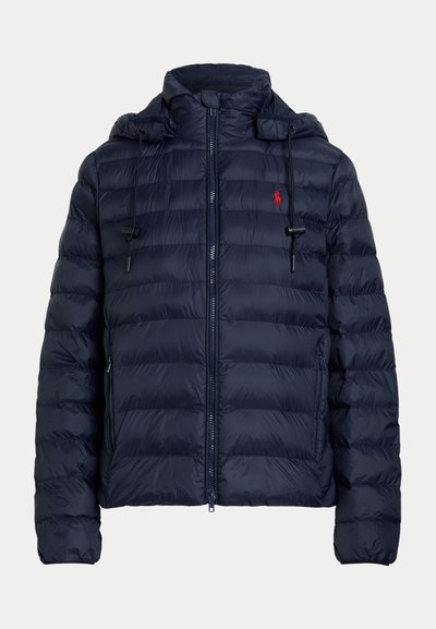 Tumesinine tikitud sulejope kapuutsiga, eesmine tõmblukk, paelad, tõmblukuga küljetaskud ja väike punane logo rinnal.