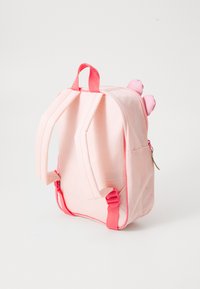 Mochila de tecido rosa com alças e fecho rosa. Possui orelhas redondas no topo, um pequeno bolso frontal e uma textura suave.