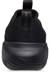 Svarta Crocs-skor med en texturerad ovandel i tyg och en slät gummisula. Har en dragflik bak med "CROCS"-logotyp.