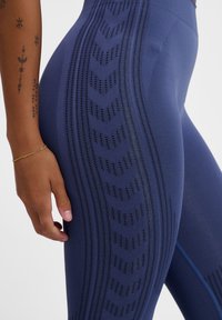 Marina leggings med ett texturerat mönster med chevrons och utskärningsdetaljer längs sidorna. Elastisk tyg och hög midja.