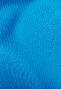 Jasnoniebieski tekstyl z gładką, jednolitą fakturą; tkany materiał o spójnym wzorze, odpowiedni do odzieży lub tapicerki.